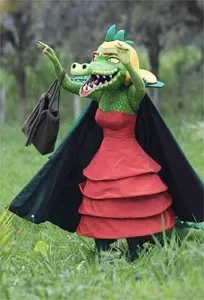 Personagem Cuca em 2004 usando um vestido vermelho tomara que caia e bolsa, ilustrando a humanização estética da fera como parte das sutis táticas do Evangelho do Dragão.